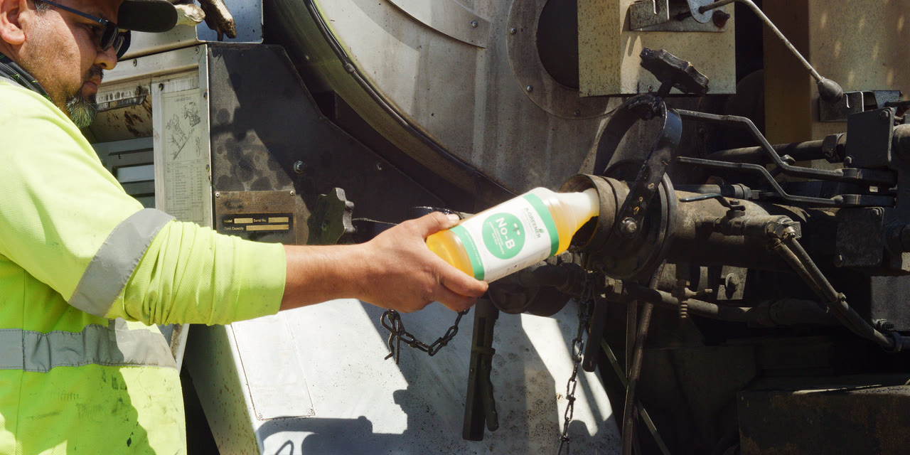 Pouring the degreaser into the load port to clear the pump