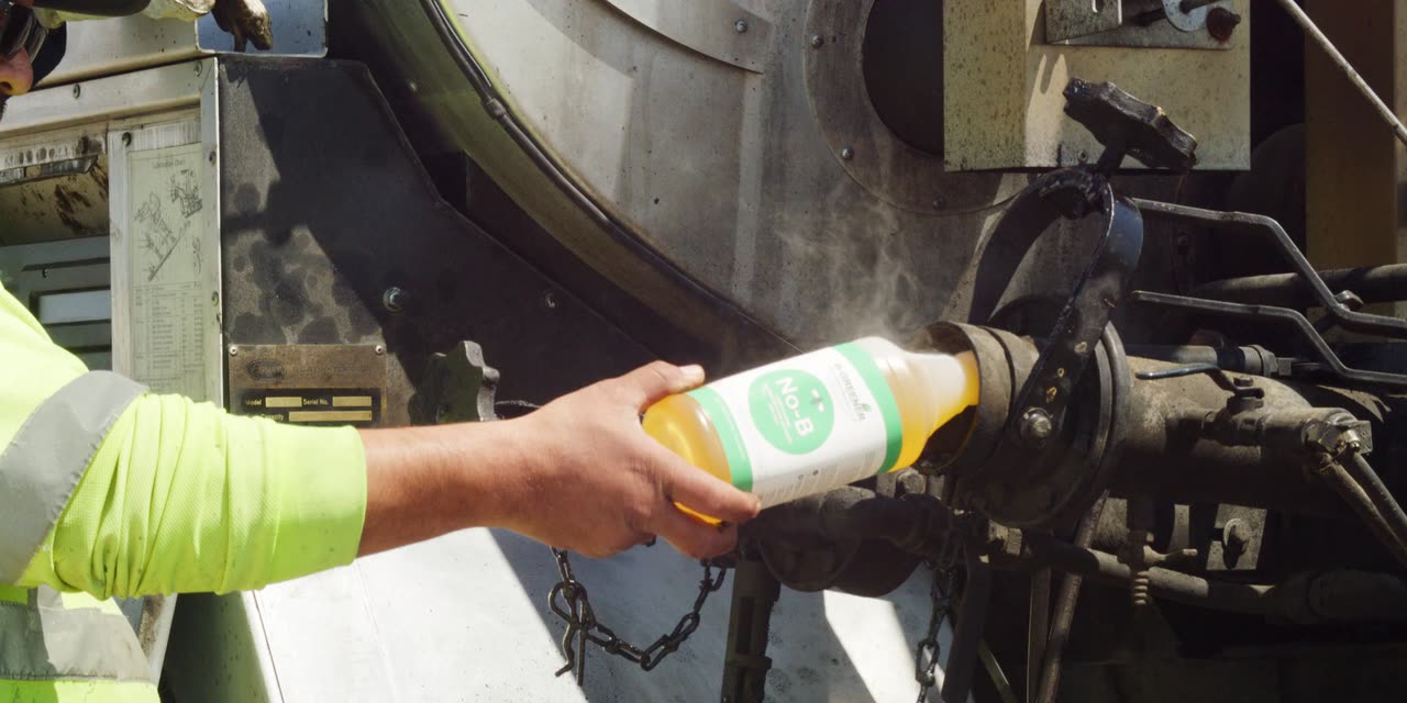 Pouring the degreaser into the load port to clear the pump